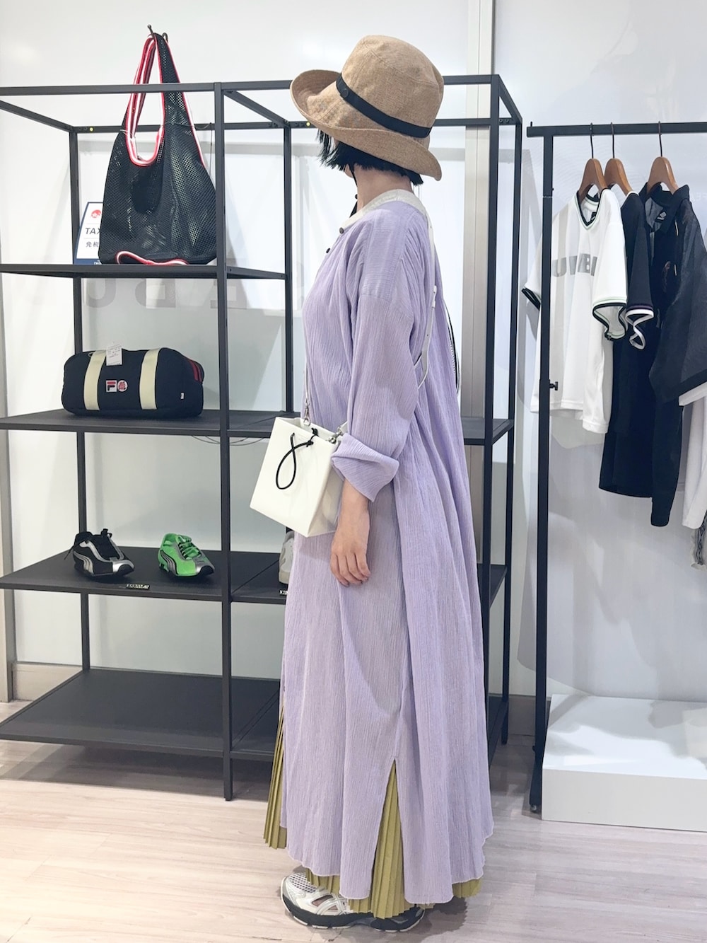 ホワイト系のショルダーバッグ、ベージュ系のTシャツ/カットソー、イエロー系のスカートを着用したレディースの夏コーディネートの3枚目の写真