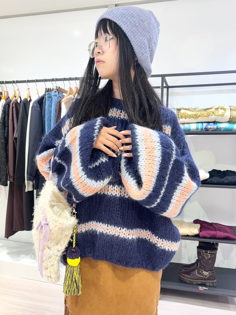 ブルー系のニット/セーター、ホワイト系のショルダーバッグ、ブラウン系のスカートを着用したレディースの秋コーディネートの5枚目の写真