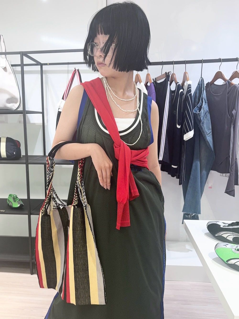 レッド系のニット/セーター、レッド系のショルダーバッグ、ブラック系のサンダルを着用したレディースの夏コーディネートの4枚目の写真