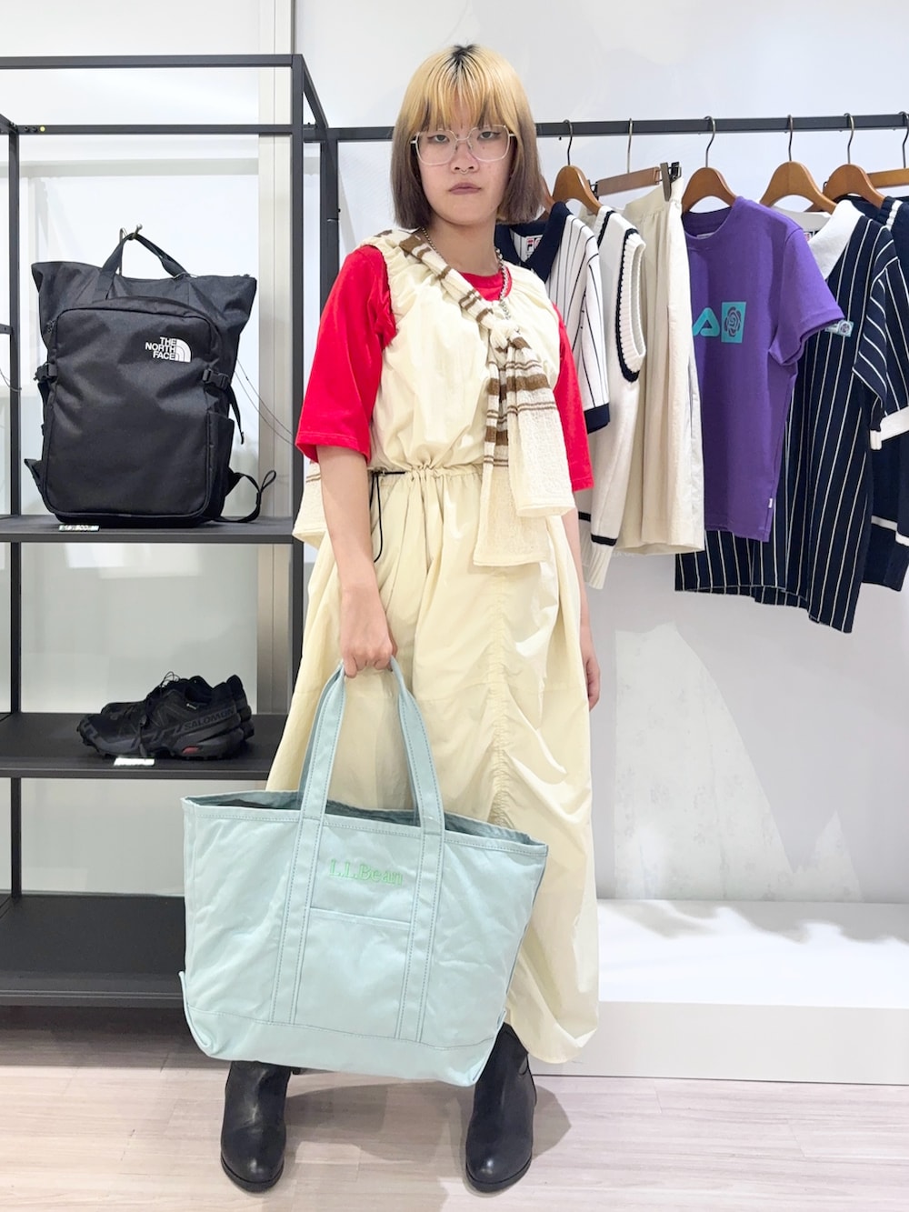 ブラック系のブーツ、ホワイト系のカーディガン/ボレロ、レッド系のTシャツ/カットソーを着用したレディースの夏コーディネートの2枚目の写真