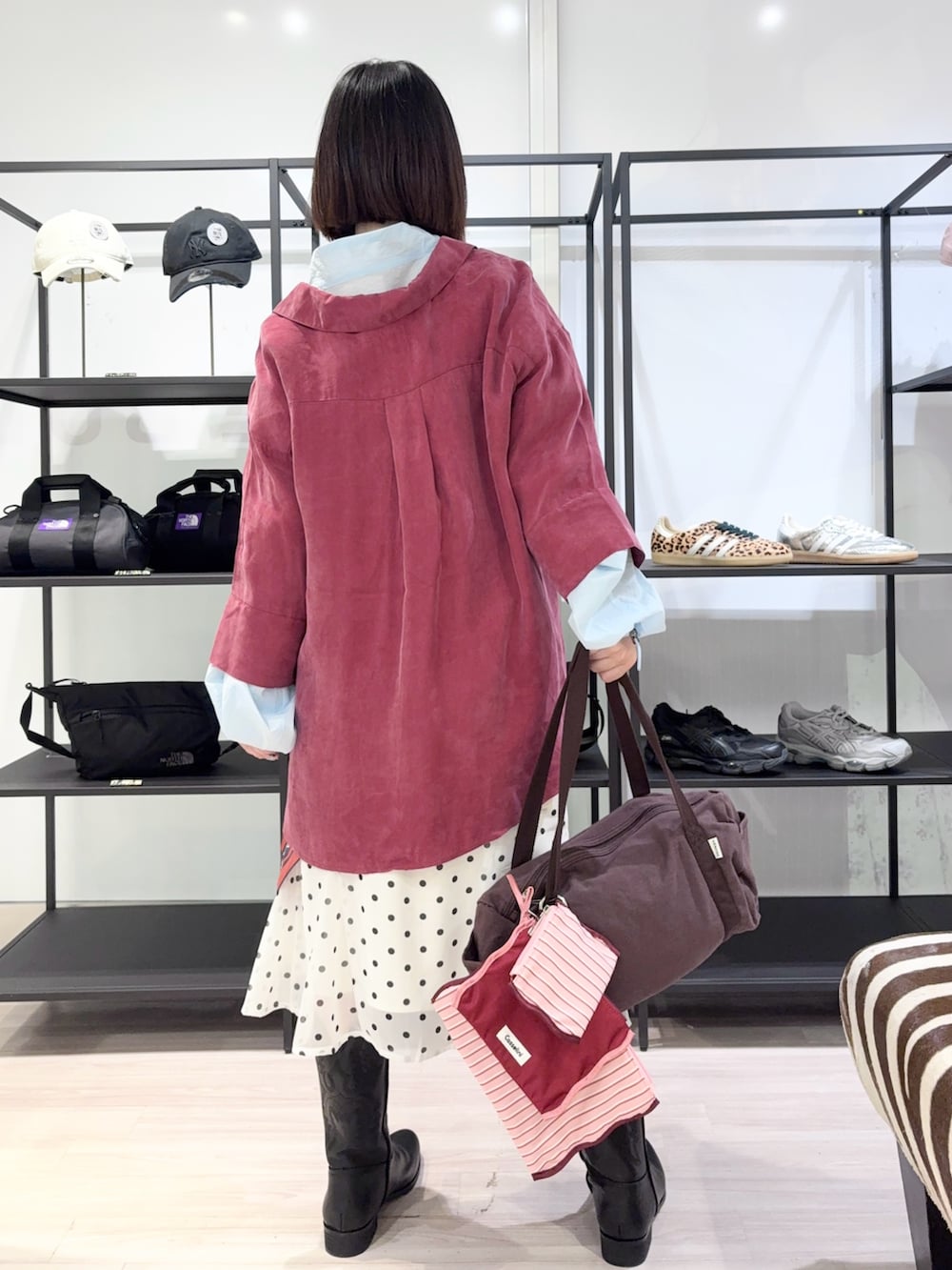 ブルー系のブルゾン、ブラウン系のボストンバッグ、ブラック系のブーツを着用したレディースの春コーディネートの4枚目の写真