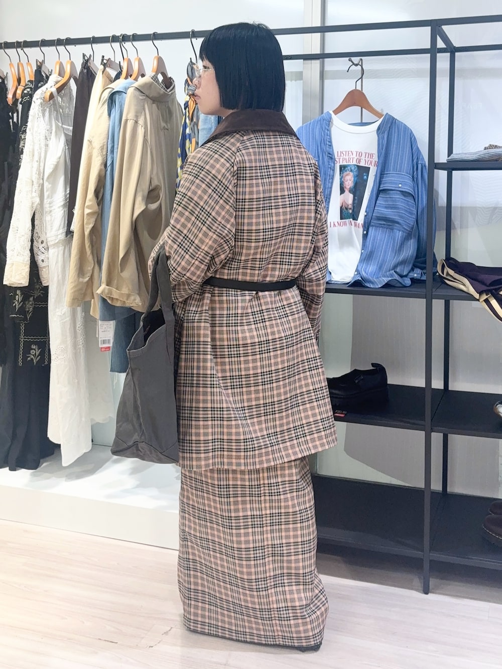 イエロー系のニット/セーター、オレンジ系のステンカラーコート、ブラック系のスニーカーを着用したレディースの秋コーディネートの4枚目の写真