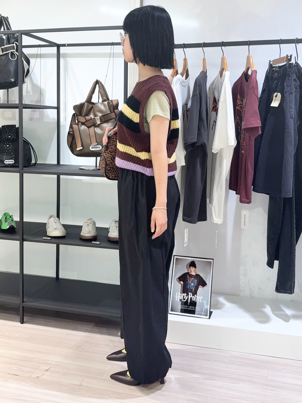 グリーン系のTシャツ/カットソー、ブラウン系のベスト、ブラック系のその他パンツを着用したレディースの秋コーディネートの3枚目の写真