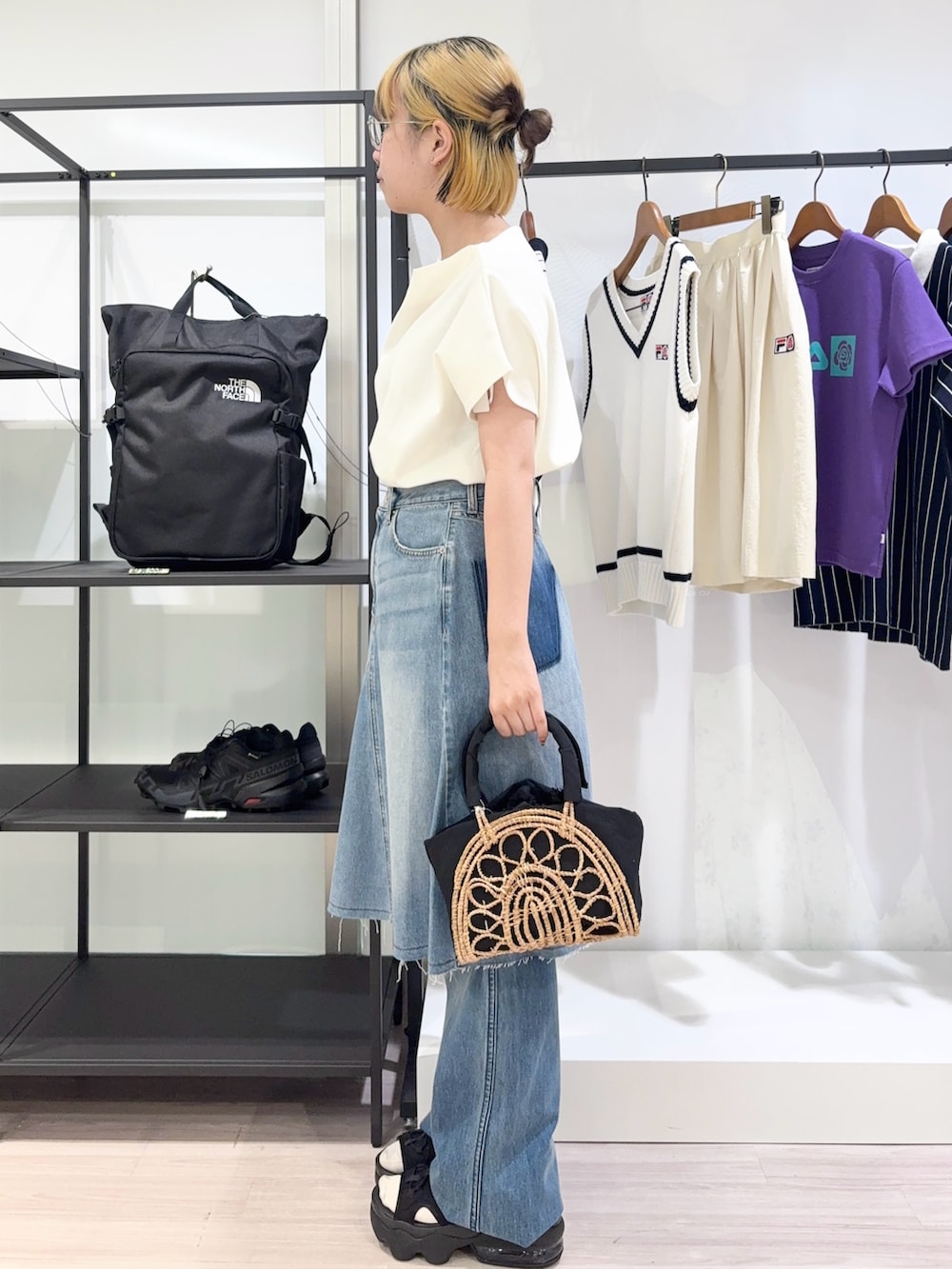 ブラック系のかごバッグ、ブルー系のデニムパンツ、ブラック系のサンダルを着用したレディースの夏コーディネートの2枚目の写真