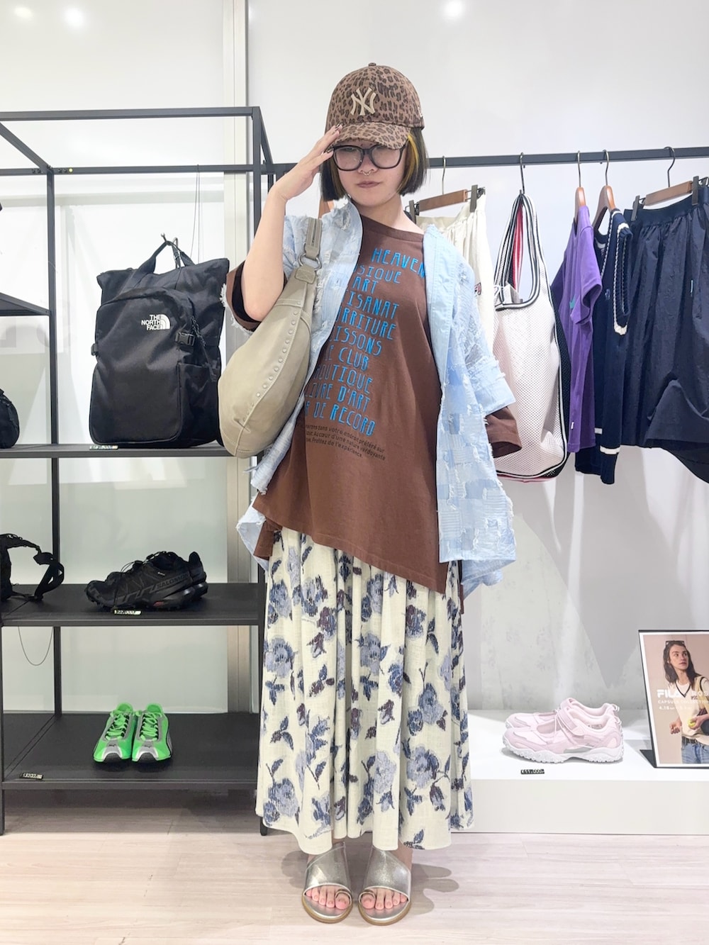 ブラウン系のTシャツ/カットソー、ホワイト系のスカート、ブラウン系のキャップを着用したレディースの春コーディネートの2枚目の写真