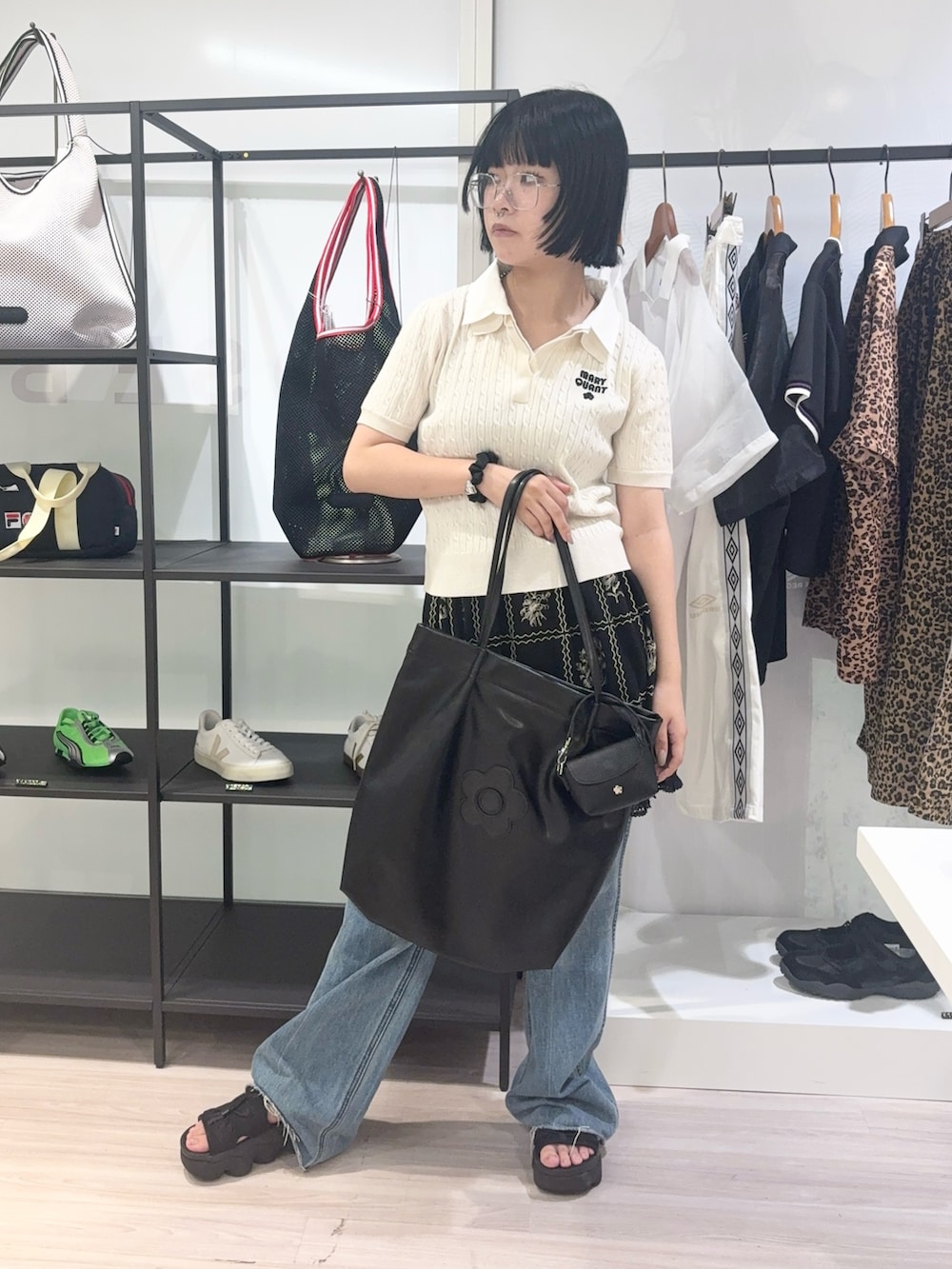 ブルー系のデニムパンツ、ブラック系のサンダル、ブラック系のカーディガン/ボレロを着用したレディースの夏コーディネートの2枚目の写真