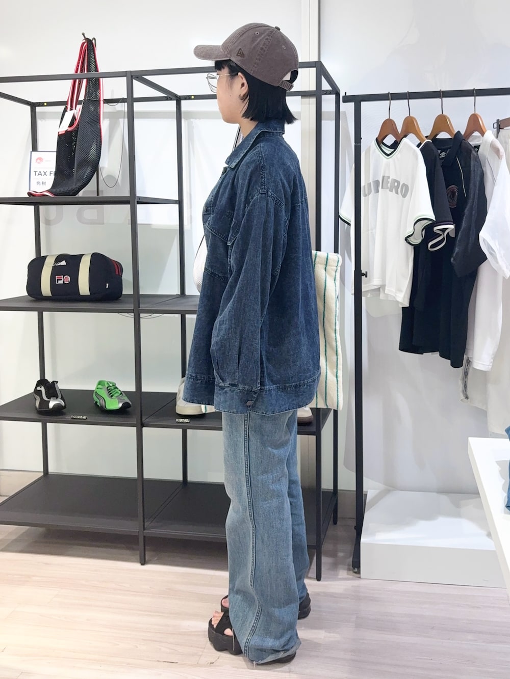 ブルー系のデニムパンツ、ブラック系のサンダル、イエロー系のTシャツ/カットソーを着用したレディースの夏コーディネートの3枚目の写真
