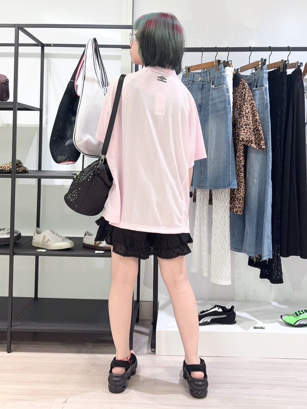 ブラック系のショルダーバッグ、ピンク系のTシャツ/カットソー、ブラック系のサンダルを着用したレディースの夏コーディネートの4枚目の写真