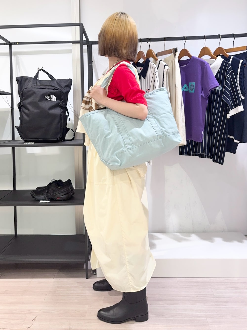 ブラック系のブーツ、ホワイト系のカーディガン/ボレロ、レッド系のTシャツ/カットソーを着用したレディースの夏コーディネートの3枚目の写真