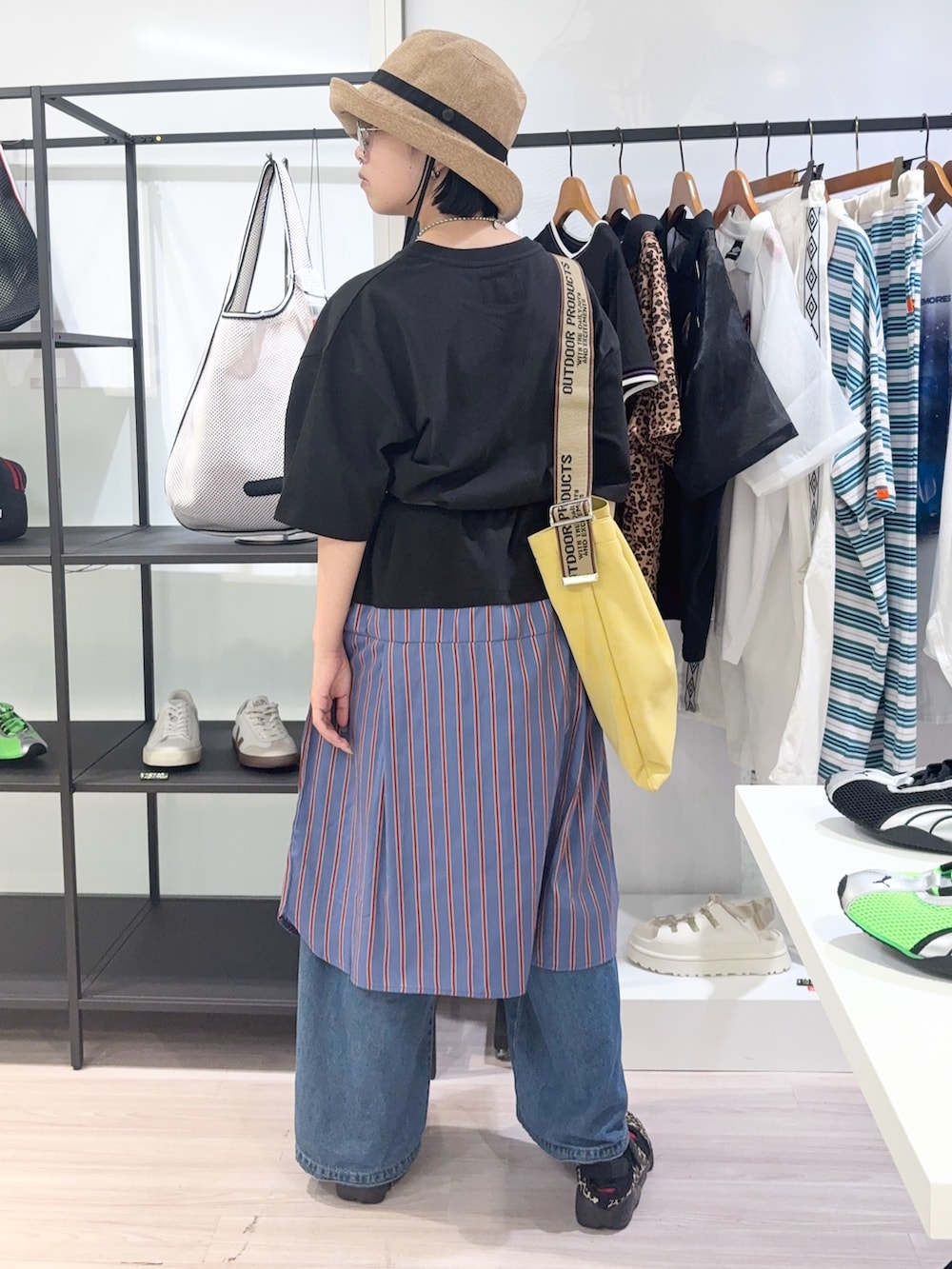 ブルー系のデニムパンツ、ブラック系のスニーカー、イエロー系のトートバッグを着用したレディースの夏コーディネートの4枚目の写真