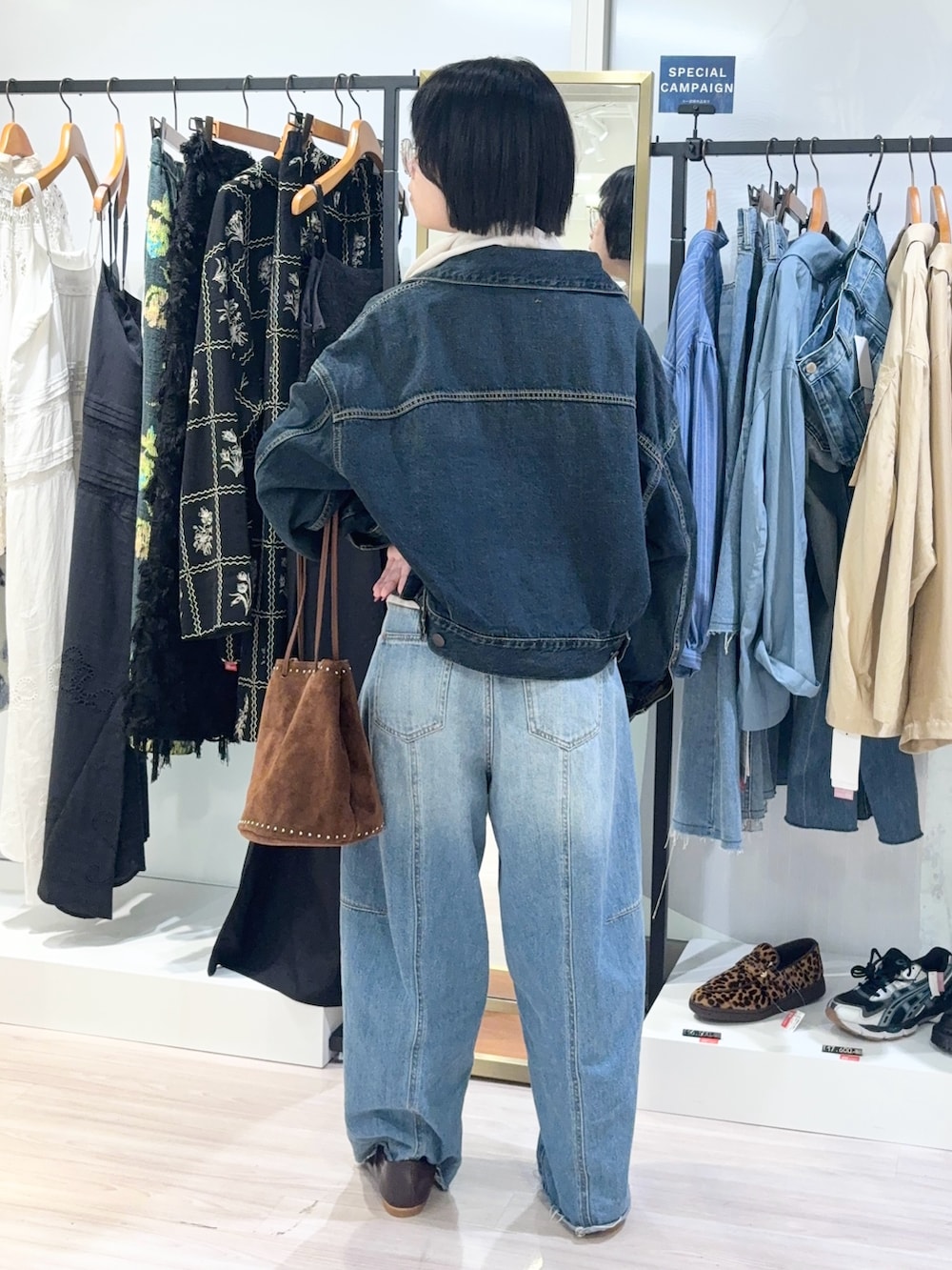 ベージュ系のTシャツ/カットソー、ブルー系のデニムパンツ、ブラウン系のショルダーバッグを着用したレディースの秋コーディネートの4枚目の写真