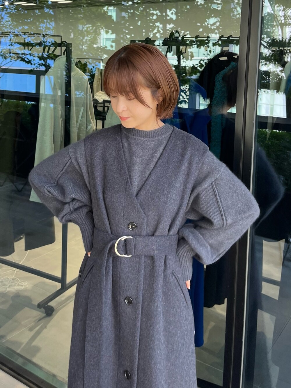 ブラック系のステンカラーコートを着用したレディースの秋コーディネートの2枚目の写真