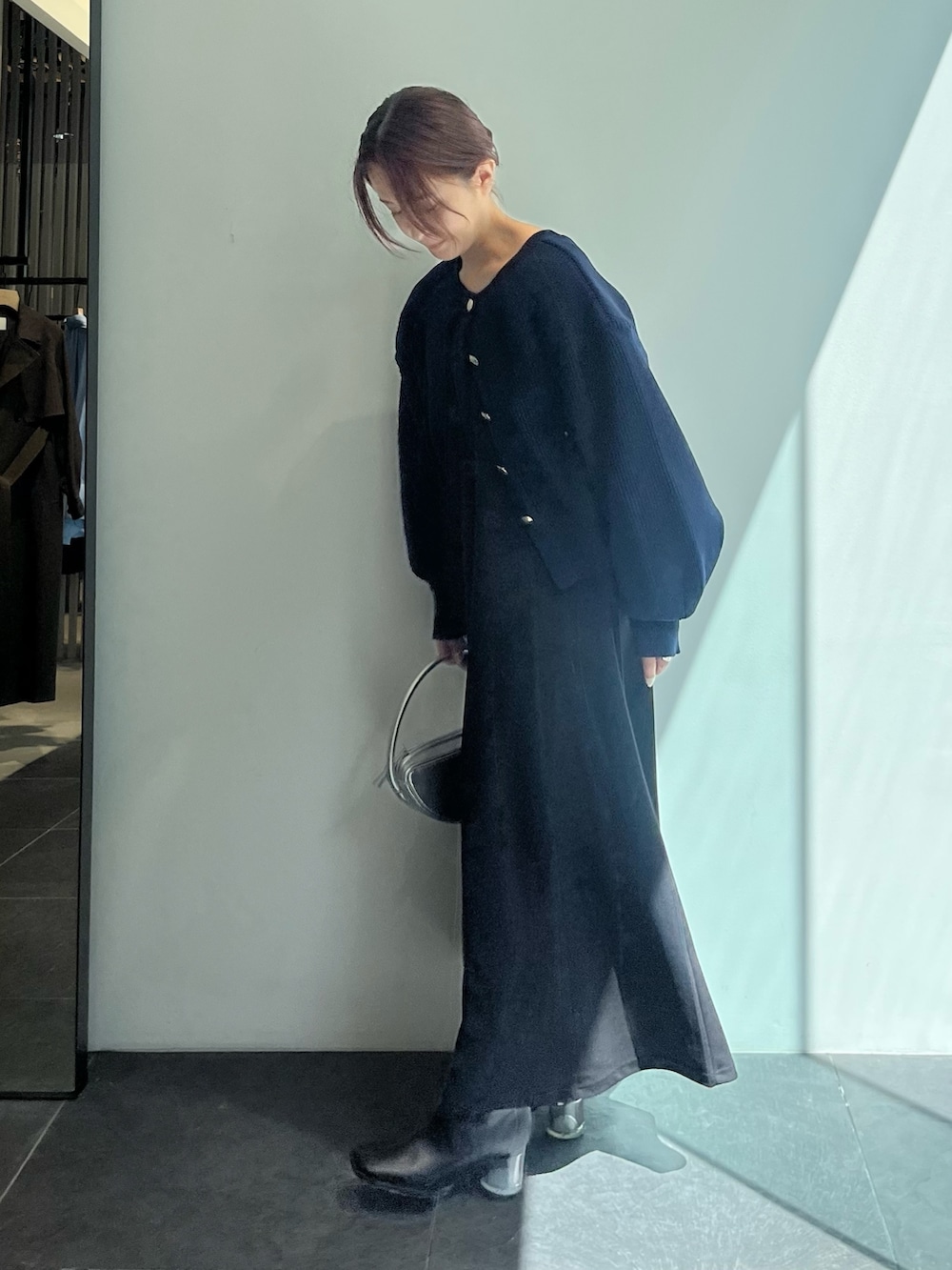 ブルー系のカーディガン/ボレロ、ブラック系のワンピースを着用したレディースの秋コーディネートの2枚目の写真