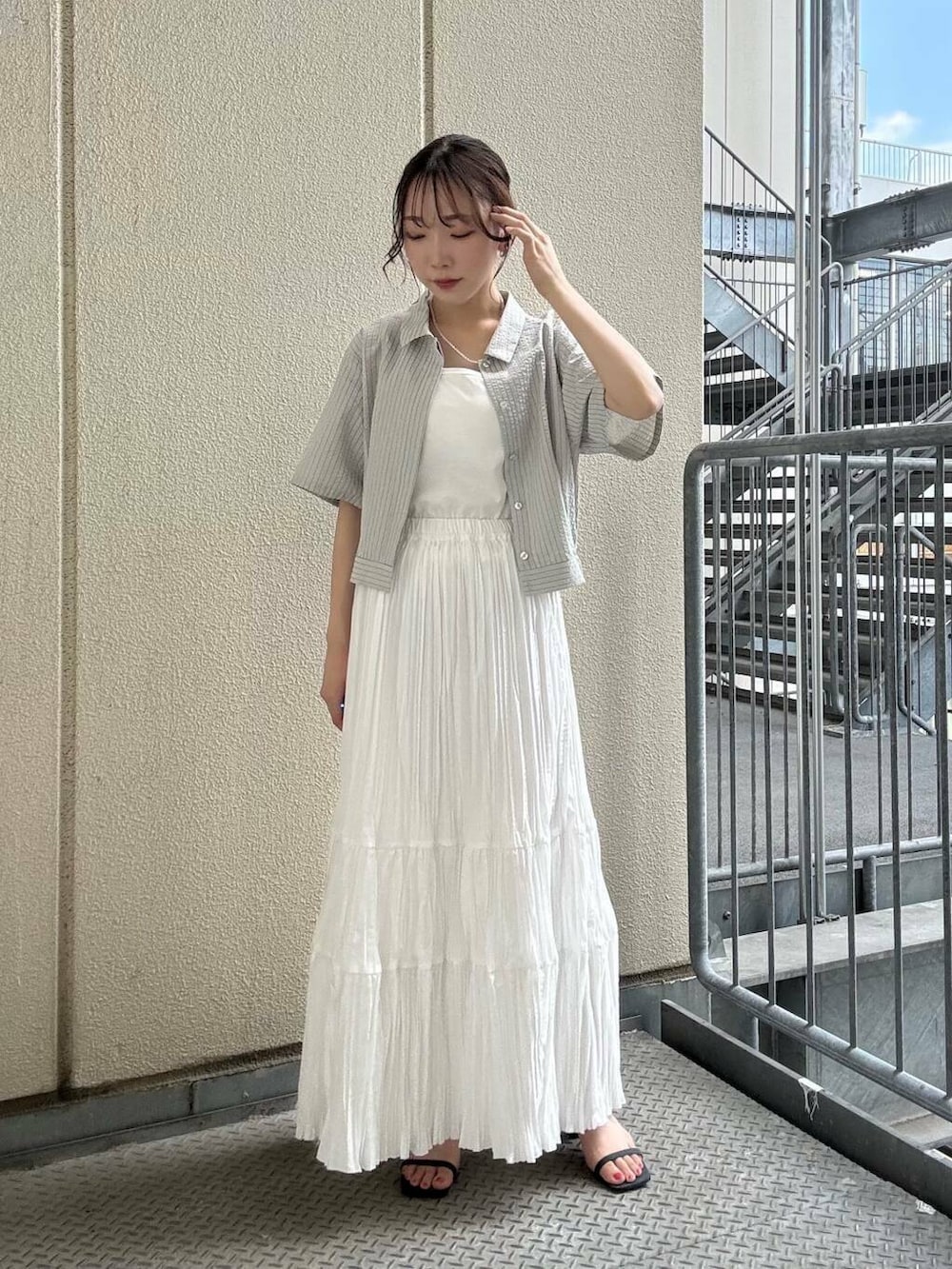 グレー系のシャツ/ブラウス、ブルー系のサンダル、ホワイト系のキャミソールを着用したレディースの夏コーディネートの2枚目の写真
