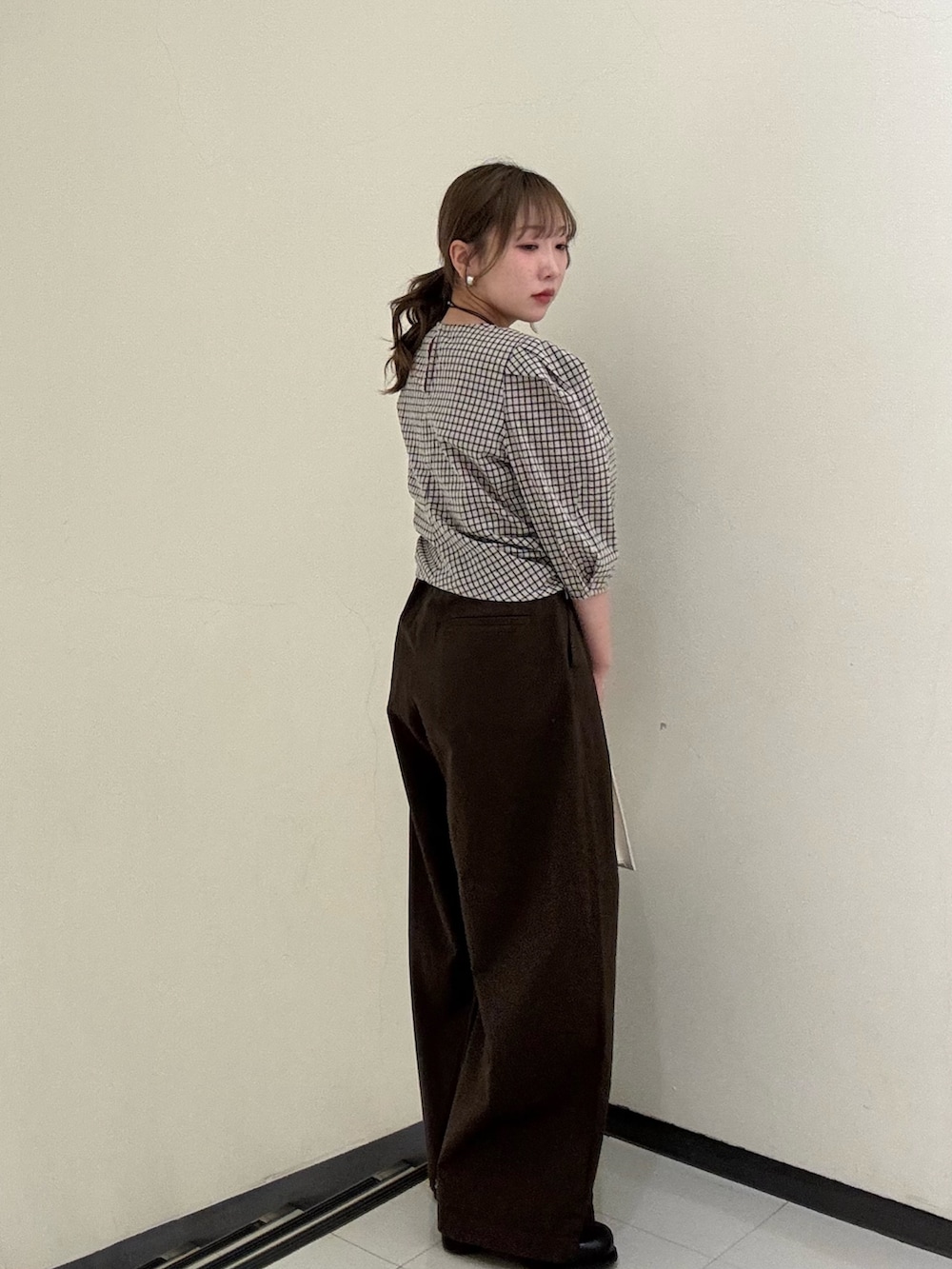 ベージュ系のシャツ/ブラウス、ブラウン系のその他パンツ、ホワイト系のハンドバッグを着用したレディースの春コーディネートの3枚目の写真