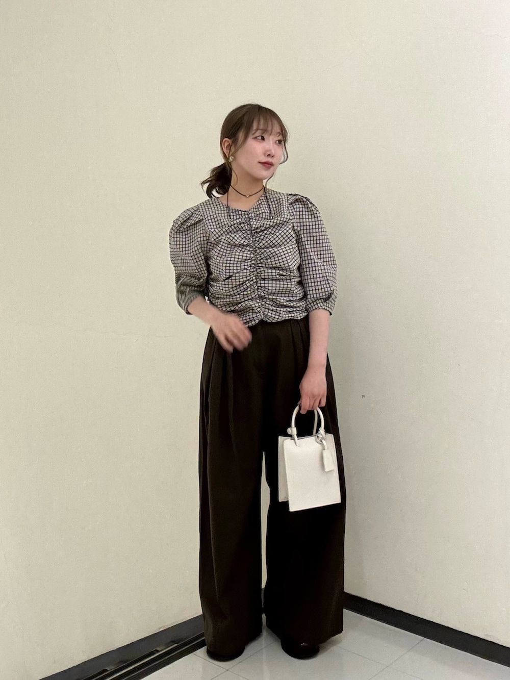 ベージュ系のシャツ/ブラウス、ブラウン系のその他パンツ、ホワイト系のハンドバッグを着用したレディースの春コーディネートの2枚目の写真