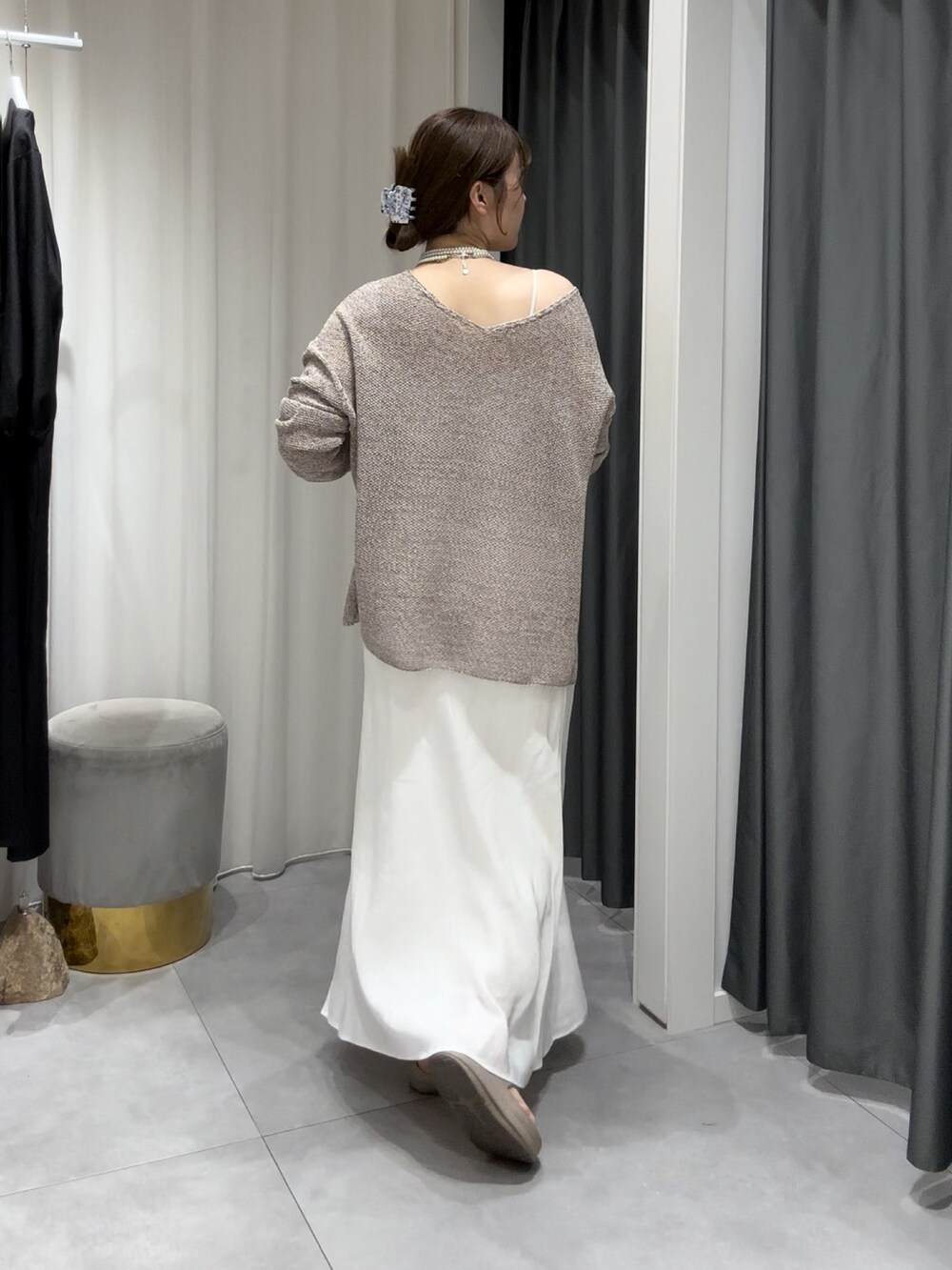 ベージュ系のニット/セーター、ホワイト系のスカート、シルバー系のネックレスを着用したレディースの夏コーディネートの4枚目の写真