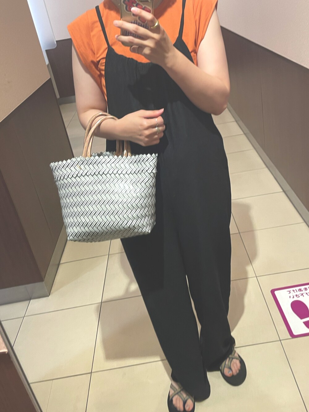 ブラック系のサロペット/オーバーオール、オレンジ系のTシャツ/カットソーを着用したレディースの夏コーディネートの2枚目の写真