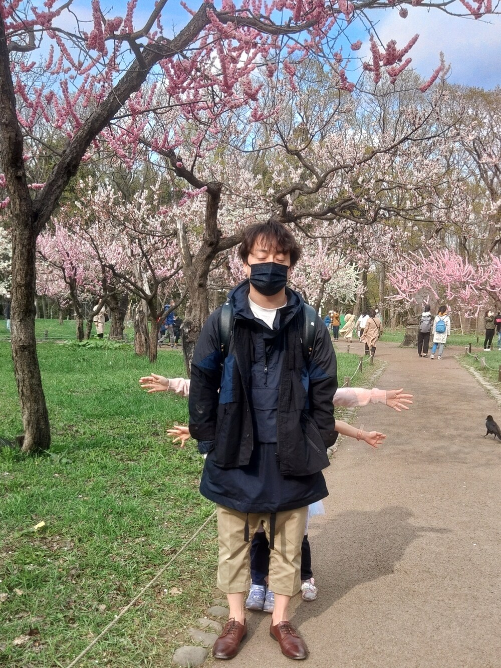 ブラウン系のその他シューズ、ベージュ系のチノパンツ、ブラック系のその他アウターを着用したメンズの春コーディネートの3枚目の写真