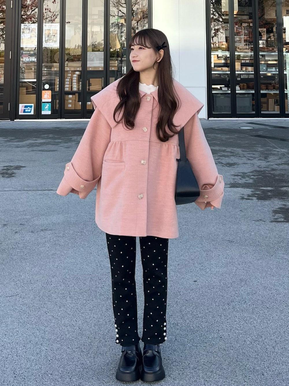 ピンク系のジャケット/アウター、ブラック系のその他パンツ、ブラック系のショルダーバッグを着用したレディースの冬コーディネートの2枚目の写真