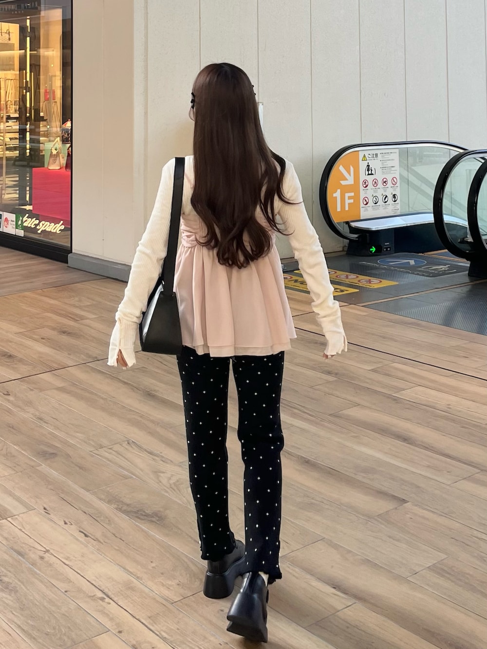 ピンク系のジャケット/アウター、ブラック系のその他パンツ、ブラック系のショルダーバッグを着用したレディースの冬コーディネートの4枚目の写真