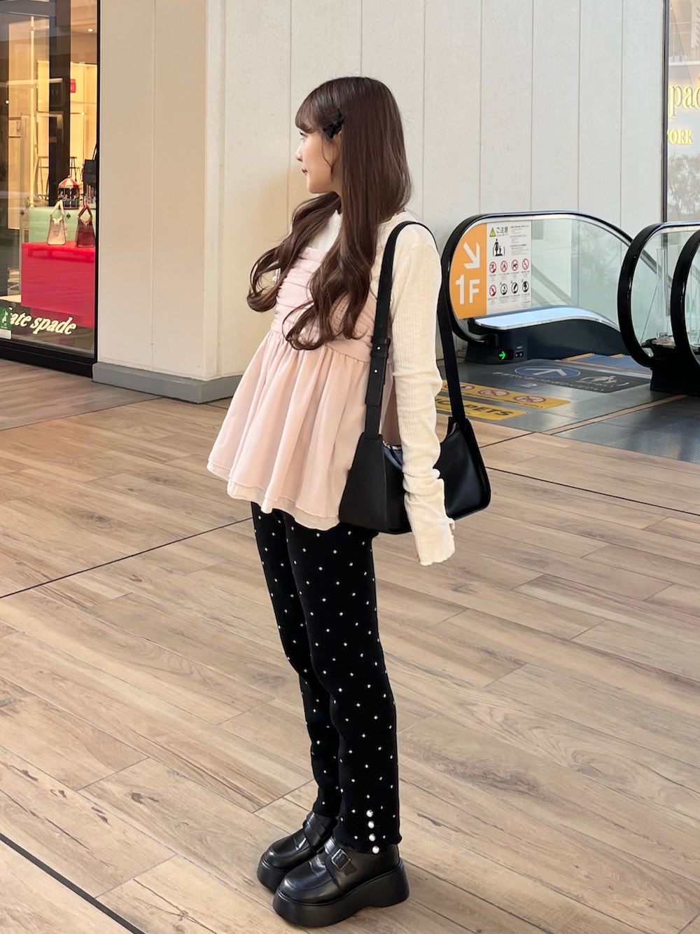 ピンク系のジャケット/アウター、ブラック系のその他パンツ、ブラック系のショルダーバッグを着用したレディースの冬コーディネートの3枚目の写真