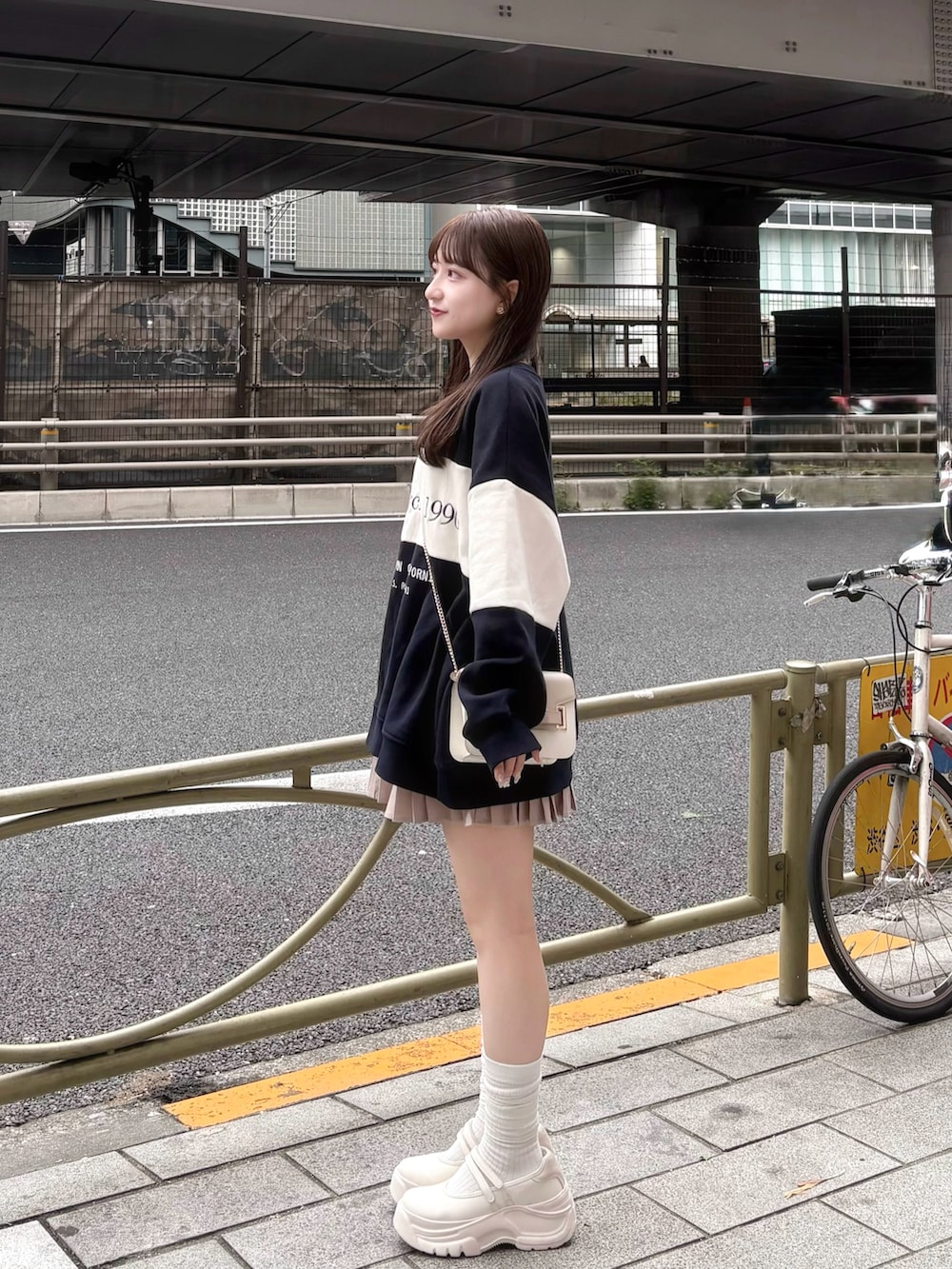 ブルー系のスウェット、ベージュ系のワンピース、ホワイト系のシューズを着用したレディースの秋コーディネートの2枚目の写真