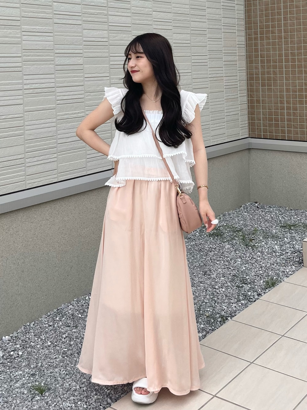 ピンク系のスカート、ホワイト系のシャツ/ブラウス、ピンク系のショルダーバッグを着用したレディースの夏コーディネートの2枚目の写真