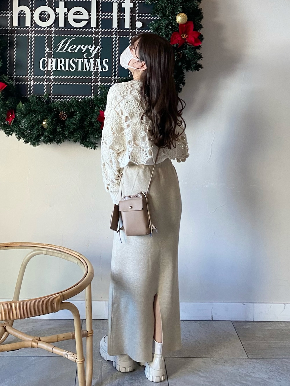 ホワイト系のニット/セーター、ホワイト系のTシャツ/カットソー、ベージュ系のショルダーバッグを着用したレディースの冬コーディネートの2枚目の写真