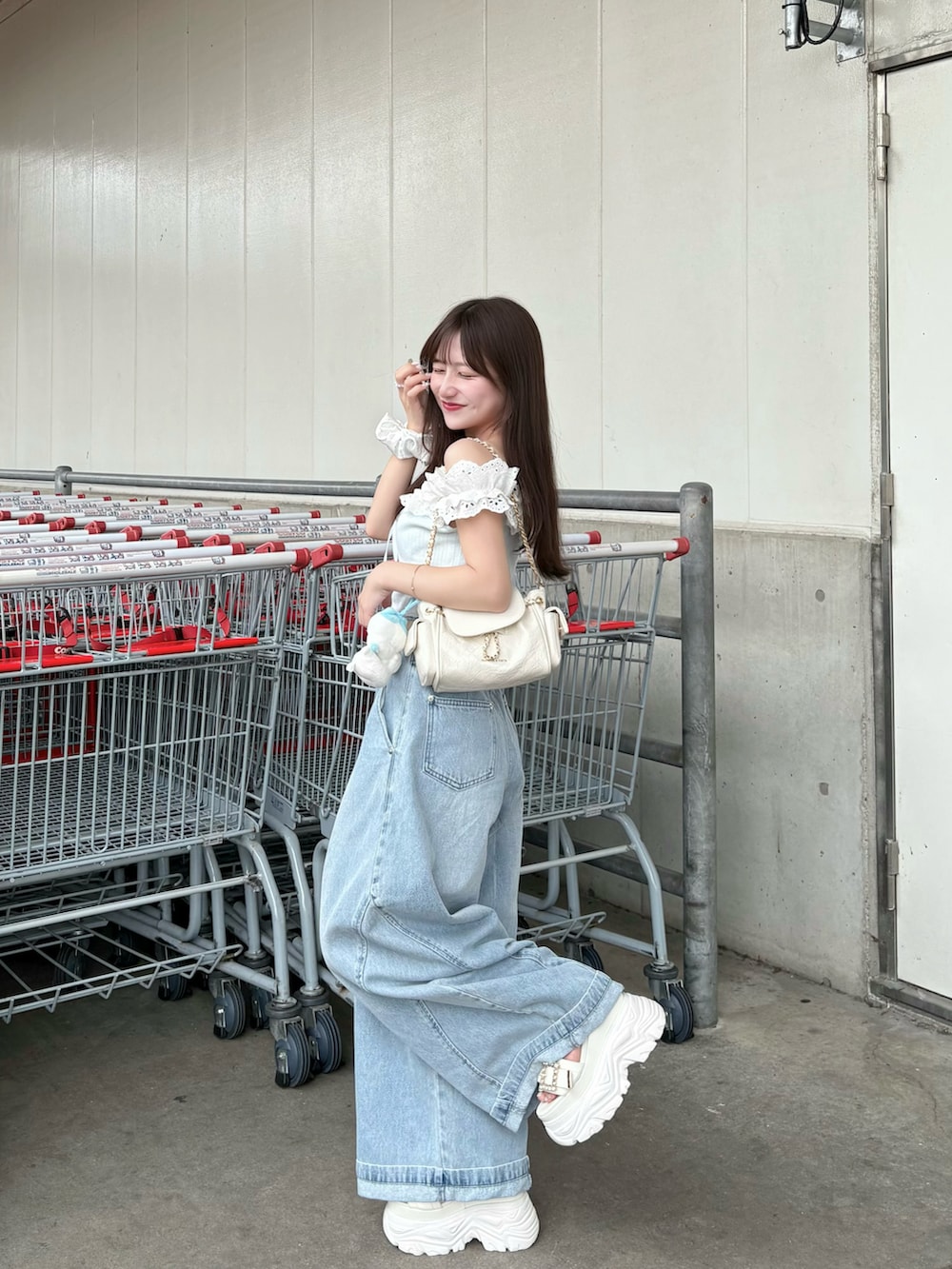 ブルー系のその他トップス、ブルー系のデニムパンツ、ベージュ系のショルダーバッグを着用したレディースの秋コーディネートの2枚目の写真