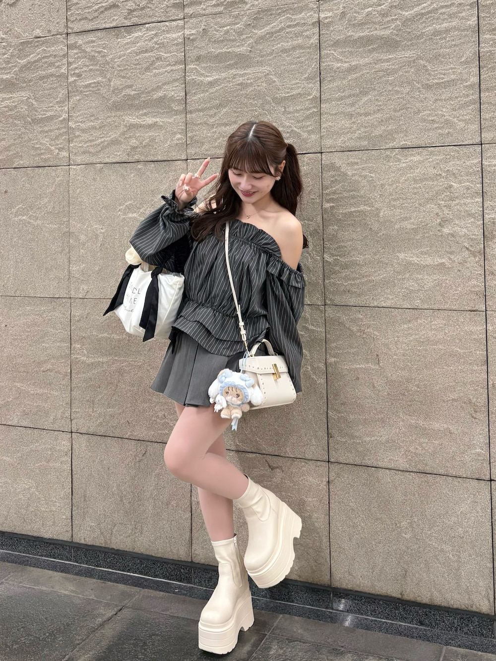 グレー系のシャツ/ブラウス、ブラック系のトートバッグ、ホワイト系のショルダーバッグを着用したレディースの秋コーディネートの2枚目の写真