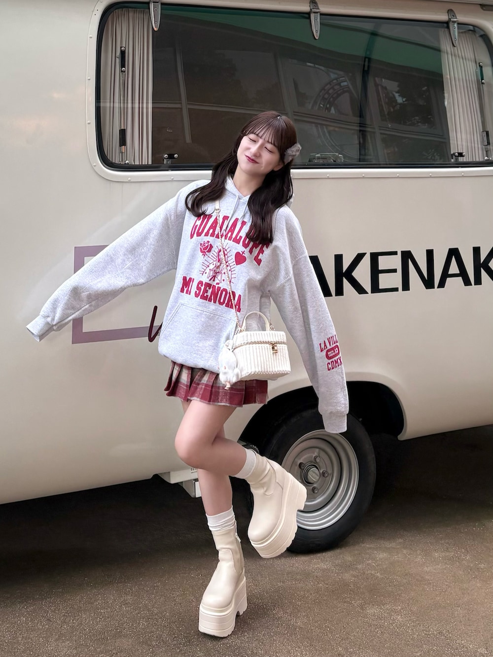 グレー系のパーカー、ホワイト系のバッグ、レッド系のスカートを着用したレディースの秋コーディネートの2枚目の写真