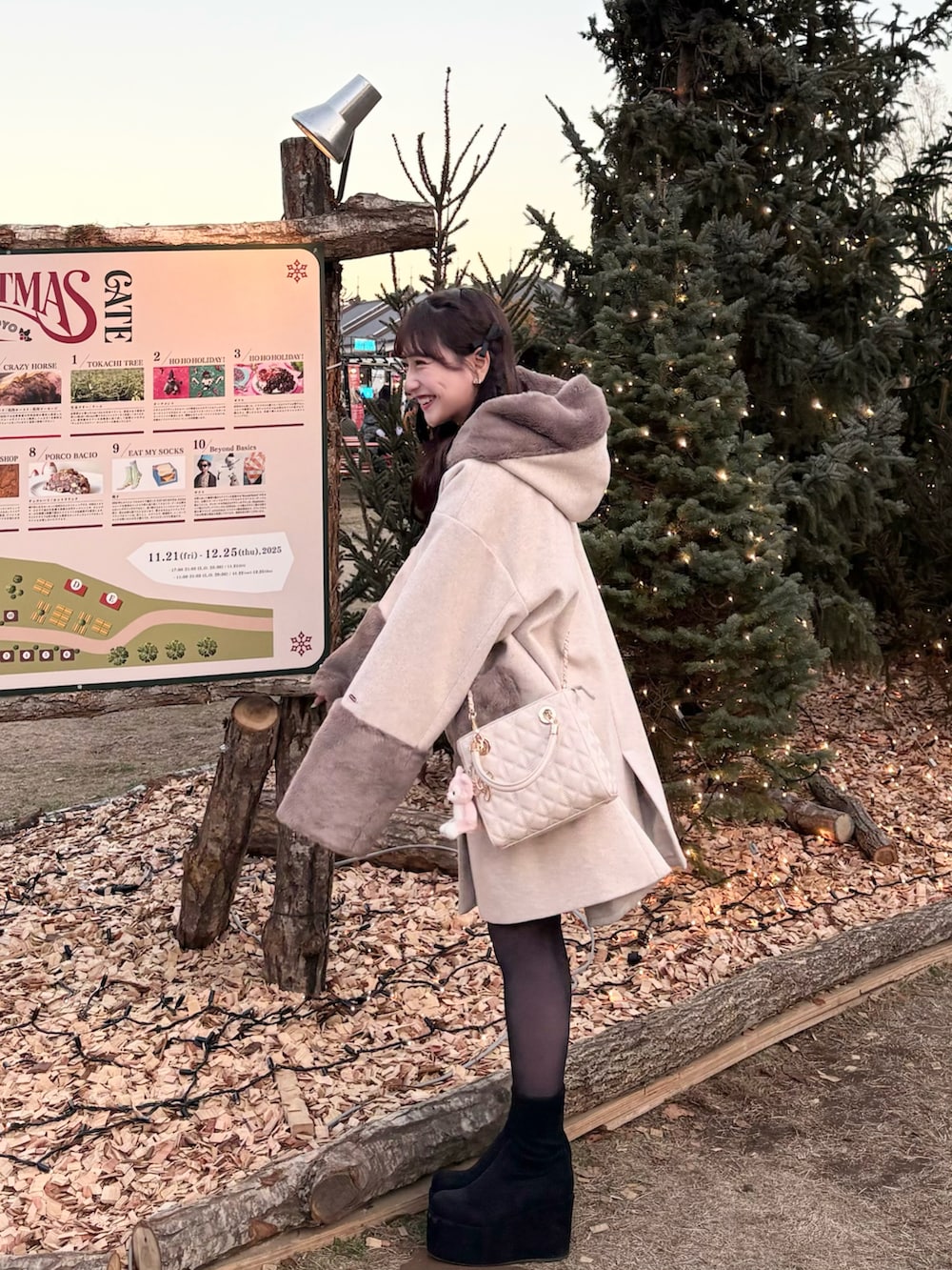 ブラウン系のジャケット/アウター、ホワイト系のハンドバッグ、ブラック系のブーツを着用したレディースの冬コーディネートの2枚目の写真