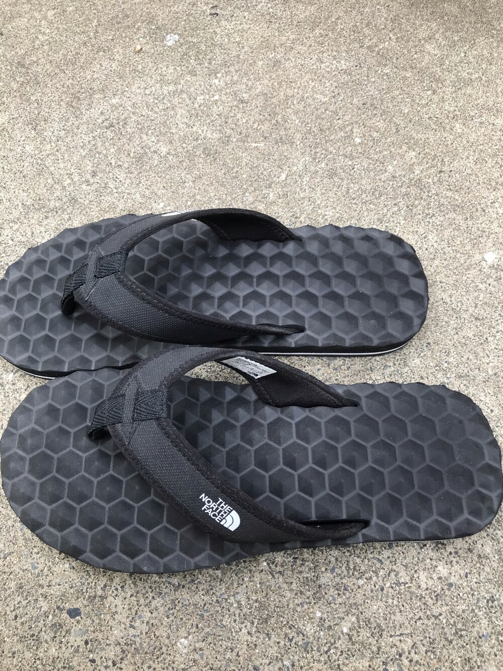 ホワイト系のTシャツ/カットソー、グリーン系のパンツ、ブラック系のサンダルを着用したメンズの夏コーディネートの3枚目の写真