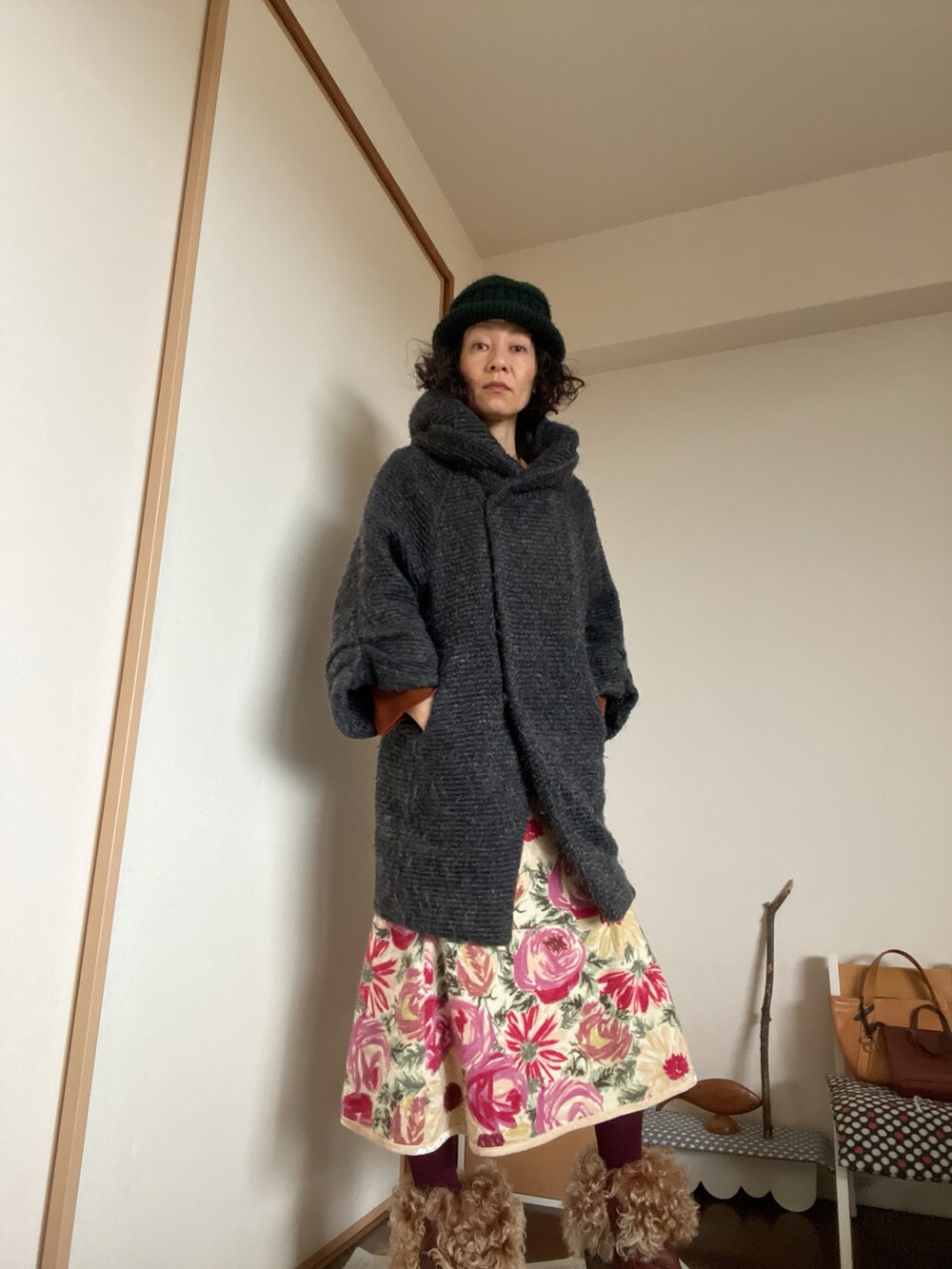 ブラウン系のニット/セーター、その他のスカート、ブラウン系のブーツを着用したレディースの冬コーディネートの2枚目の写真