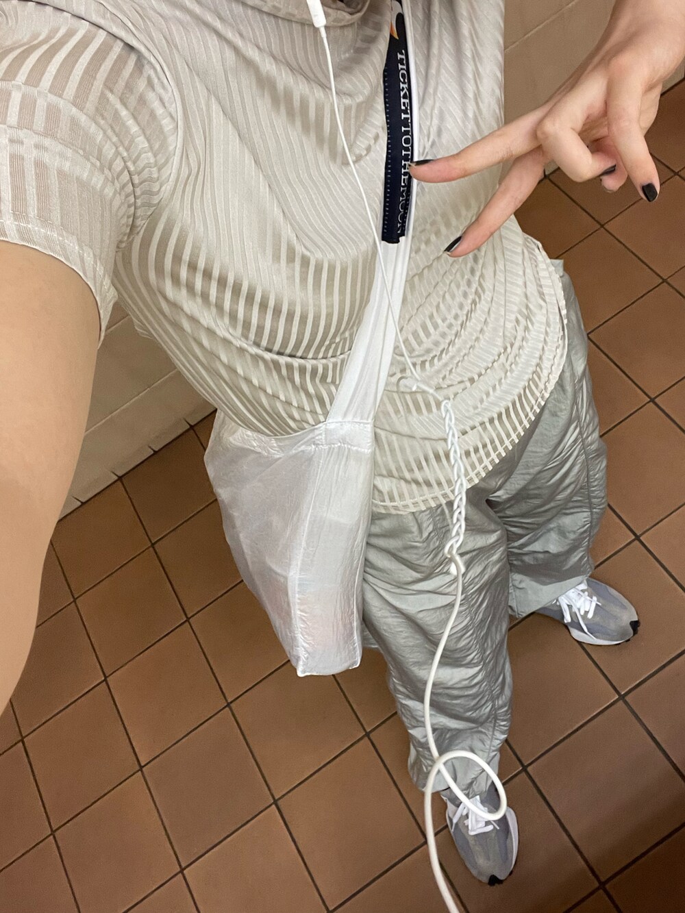 グレー系のスニーカー、シルバー系のパンツ、シルバー系のTシャツ/カットソーを着用したレディースの夏コーディネートの3枚目の写真