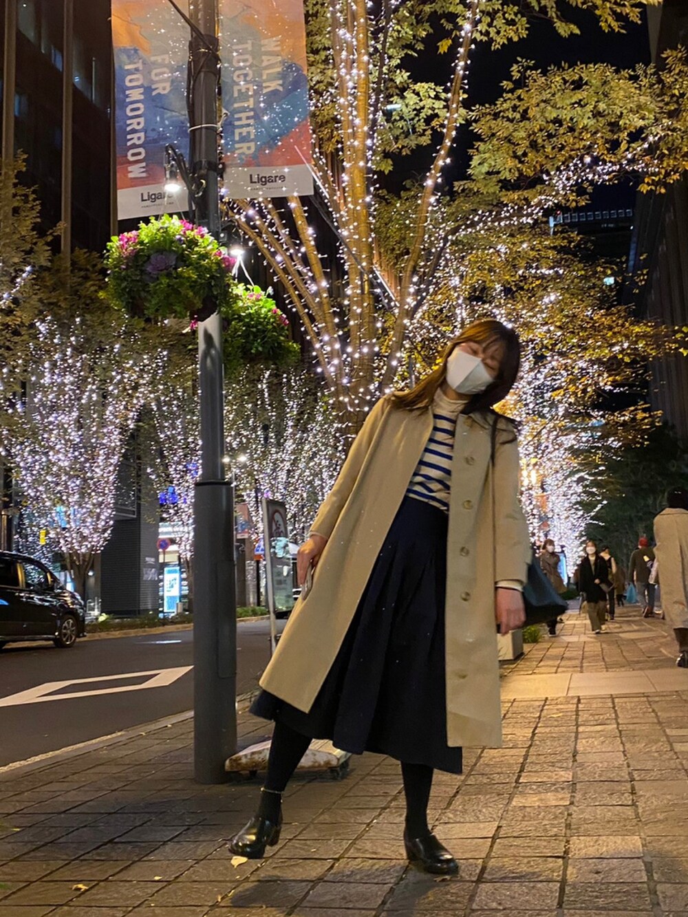 ベージュ系のジャケット/アウター、ブルー系のスカート、ブラック系のローファーを着用したレディースの秋コーディネートの2枚目の写真