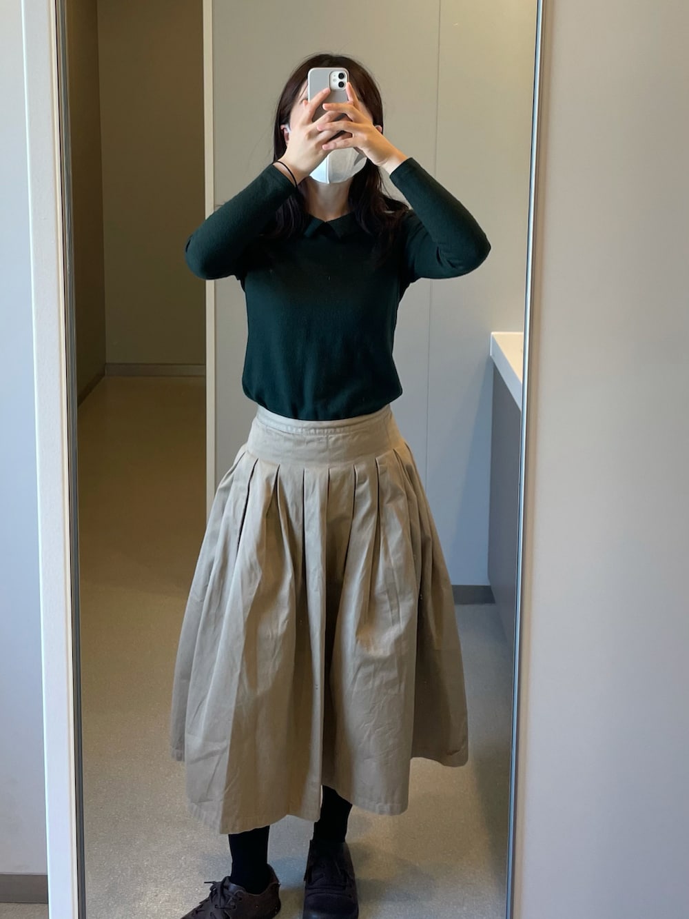 ベージュ系のスカート、ブラウン系のサンダルを着用したレディースの秋コーディネートの2枚目の写真