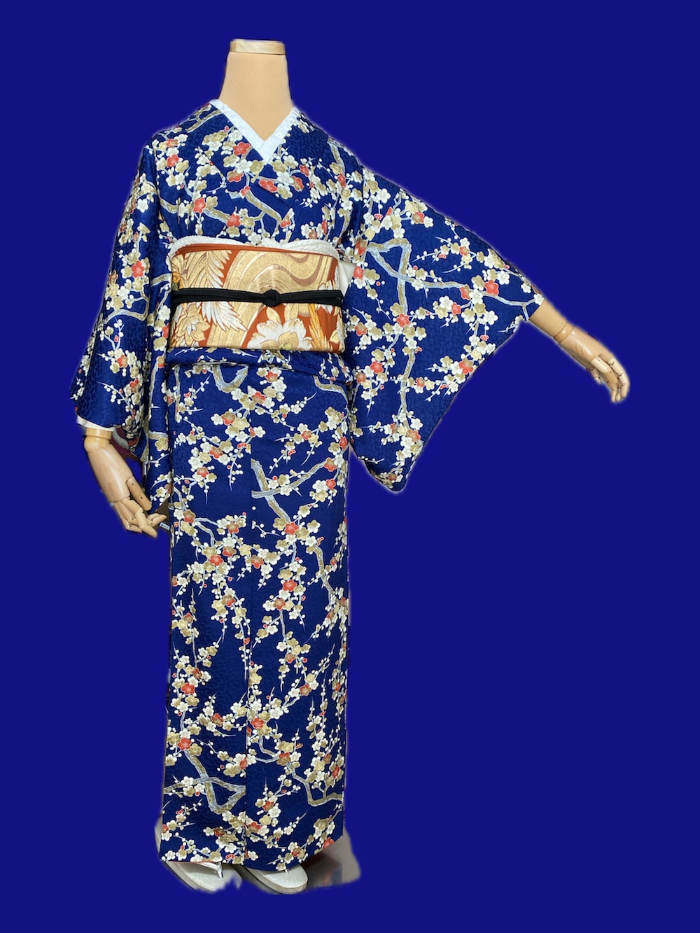 レッド系のノーカラージャケット、ブルー系の着物、オレンジ系のベルトを着用したレディースの冬コーディネートの3枚目の写真