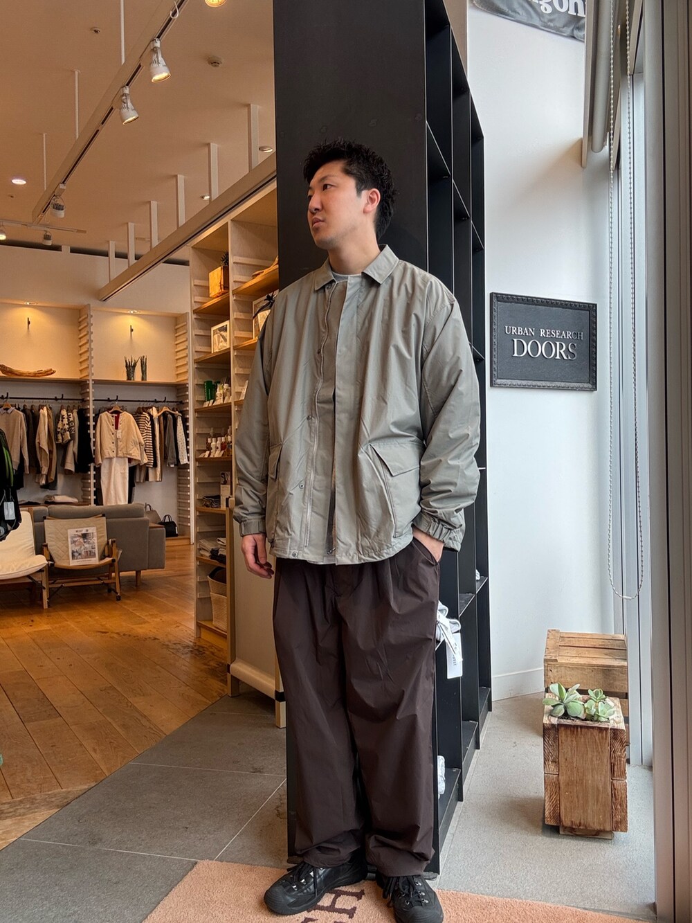 グリーン系のナイロンジャケットを着用したメンズの秋コーディネートの2枚目の写真