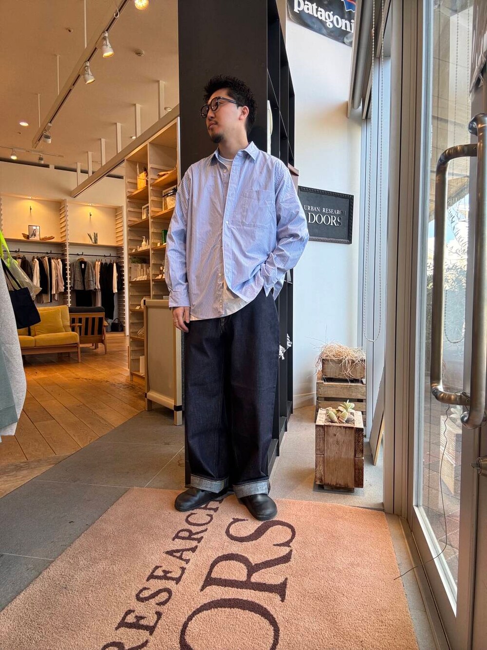 ブルー系のシャツ/ブラウス、ブラック系のブルゾン、ブルー系のデニムパンツを着用したメンズの春コーディネートの3枚目の写真