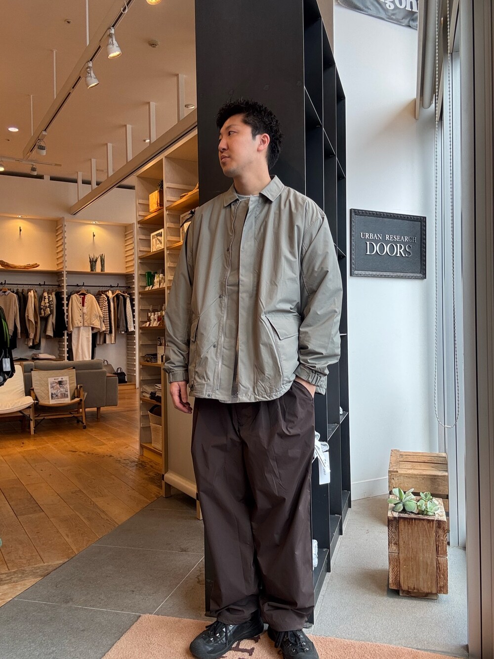 グリーン系のナイロンジャケットを着用したメンズの秋コーディネートの3枚目の写真