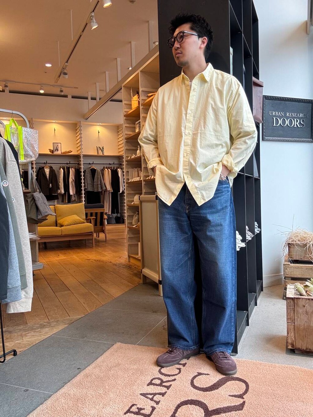 ブルー系のデニムパンツ、ブラウン系のスニーカーを着用したメンズの春コーディネートの3枚目の写真