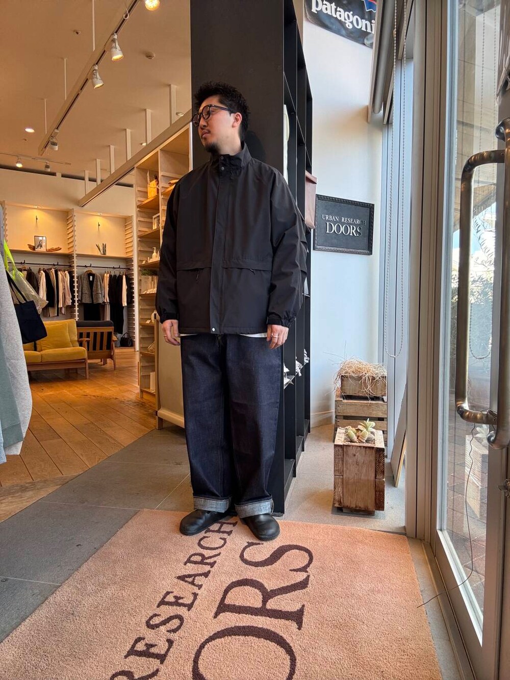 ブルー系のシャツ/ブラウス、ブラック系のブルゾン、ブルー系のデニムパンツを着用したメンズの春コーディネートの2枚目の写真