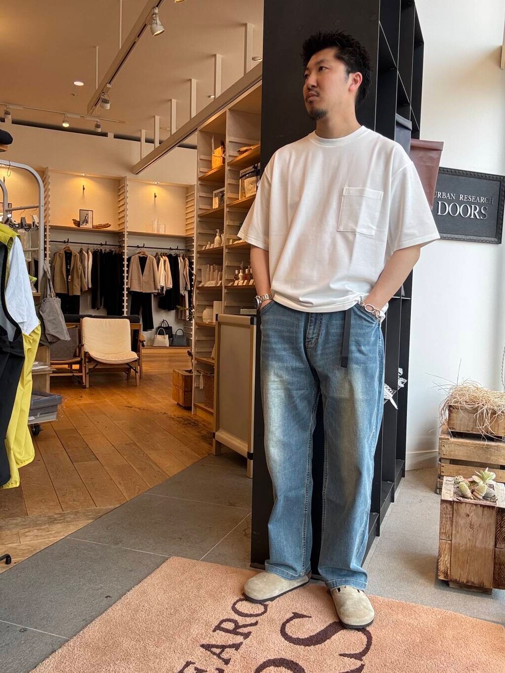 ブルー系のデニムパンツ、ホワイト系のTシャツ/カットソー、グリーン系のシャツ/ブラウスを着用したメンズの春コーディネートの3枚目の写真