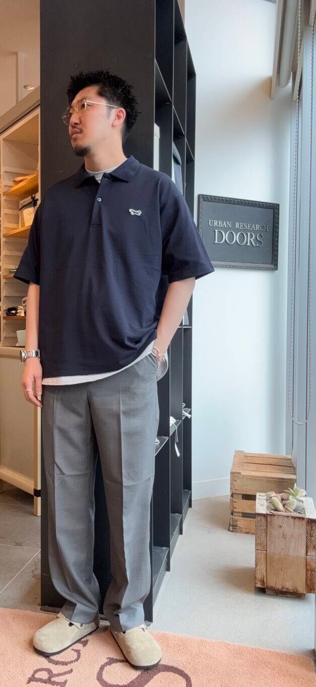 ブルー系のポロシャツ、グレー系のスラックスを着用したメンズの夏コーディネートの2枚目の写真