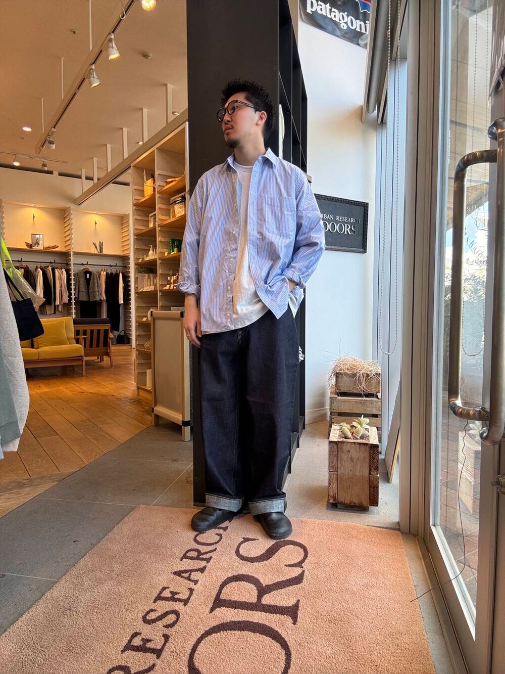 ブルー系のシャツ/ブラウス、ブラック系のブルゾン、ブルー系のデニムパンツを着用したメンズの春コーディネートの5枚目の写真