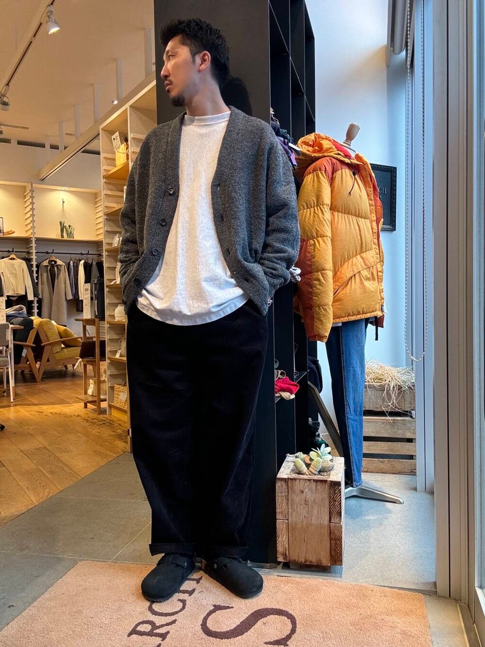 グレー系のダウンジャケット/コート、グレー系のカーディガン/ボレロ、ブラック系のその他パンツを着用したメンズの秋コーディネートの3枚目の写真