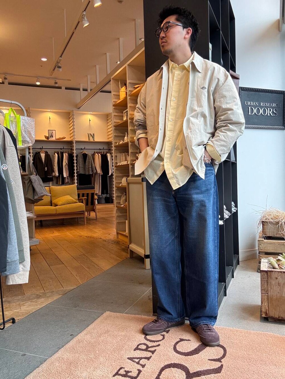 ブルー系のデニムパンツ、ブラウン系のスニーカーを着用したメンズの春コーディネートの2枚目の写真