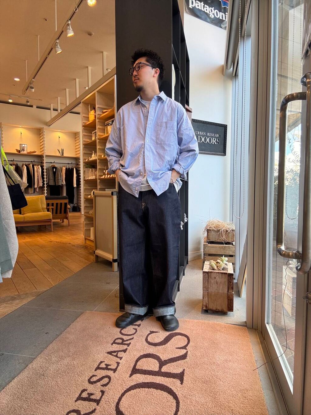 ブルー系のシャツ/ブラウス、ブラック系のブルゾン、ブルー系のデニムパンツを着用したメンズの春コーディネートの4枚目の写真